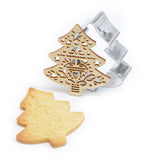 Sablés en forme d e sapin avec à coté l'emporte pièce en inox et son tampons en bois qui ont permis de réaliser la forme du biscuit et sa décoration