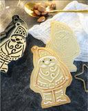 Sablées de Noël en forme de père Noël. A coté des biscuits de Noël, il y a l'emporte pièce avec son tampon qui ont permis de réaliser la forme des biscuits