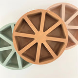 Photo de 3 moules à gâteaux en silicone, de 3 couleurs différéntes. Ils ont 8 portions differentes