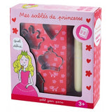 Photo d'un coffret à patisserie pour enfant : mes sablés de princesse. Le coffret est de couelur rose avec une illustration de princesse qui mange un gâteau sur le devant de l'emballage. Le coffret est transparant et on voit l'interieur qui est composé d'emportes pièces et d'un rouleau à patisserie en boie