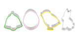 Photo de 4 emporte_pièces posés les un a coté des autres. Ils sont en inox avec des embouts en silicone de couleur. Le 1er est une cloche avec ebout vert, le 2eme à la forme d'un oeuf avec embout rose, le 3eme un poussin jaune et le dernier un lapin avec embout blanc