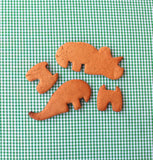 4 biscuits sablées découpés sur une nape couleur vichy vert. Une fois assembler les 4 biscuits réaliseront un dinosaure en 3D