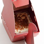 Gros plan sur des graines posées sur une petite boîte en carton, dans un animal pop up en forme d'écureuil