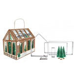 Coffret pour réaliser une maison en pain d'epice de la marque Scrapcooking. Le coffret represente une maison de pain d'épice avec à l'interieur des sapins vert