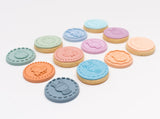 Ensemble de biscuits colorés posé les uns a coté des autres sur 3 rangés allignés. Les biscuits sont décoré avec de la pâte à sucre de couleur pastel avec des motifs sur le thème de pâques