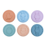 6 tampons à biscuits en silicone de couleur pastel bleu, mauve et beige. ils sont allignés sur 2 rangés de 3. Les tampons ont des motifs en 3D sur le thème de pâque