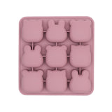 Moule multiportions de couleur rose en forme d'animaux, il y a 9 compartiment avec des formes différentes. Le moule est pris en photo sur un fond blanc, le moule est sur l'envers