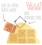 Tampon en bois en forme de dés en bois avec son découpoir en inox. Il est présenté dans son emballage. Le tampon représente des motifs de fleurs