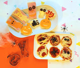 Toast et pizzas au forme d'halloween. Il sont posés dans 2 assiettes blances avec sur le coté droit de la photo 2 emporte piece aux forme de citrouille et de fantôme