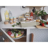 Photo d'une cuisine en bois pour enfants avec des ingrédients et de la vaisselle assortie 