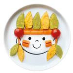 Assiette en porcelaine blanche avec une illustration de tête de bonhomme rigolos au centre. Elle est de la marque Cibolo , indiqué sur l’oval du visage. L’assiette permet de créer des repas rigolos en animant le personnage. Elle est composée de plusieurs purée avec des morceaux de carottes et des tomates cerise, elle représente un indien