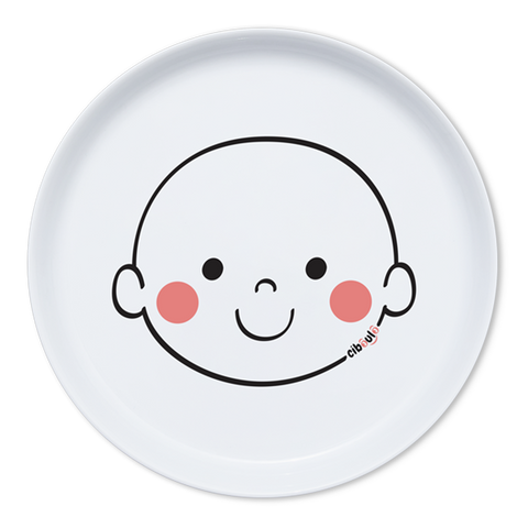 Assiette en porcelaine blanche avec une illustration de tête de bonhomme rigolos au centre. Elle est de la marque Cibolo , indiqué sur l’oval du visage. L’assiette permet de créer des repas rigolos en animant le personnage 