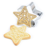 Sablés en forme d'étoile avec à coté l'emporte pièce en inox et son tampons en bois qui ont permis de réaliser la forme du biscuit et sa décoration 