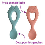 2 cuillère en silicone pour bébé avec un manche en forme de tête d'animaux. il y a également des inscriptions manuscrutes pour décrire les cuillères