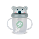 Tasse pour enfant de la marque Tum Tum sur fond blanc. La tasse est transparente avec des poignées de chaque coté et le logo de la marque au milieu. Elle a un couvercle bleu rabatable avec une tête de koala avec des oreilles en relief