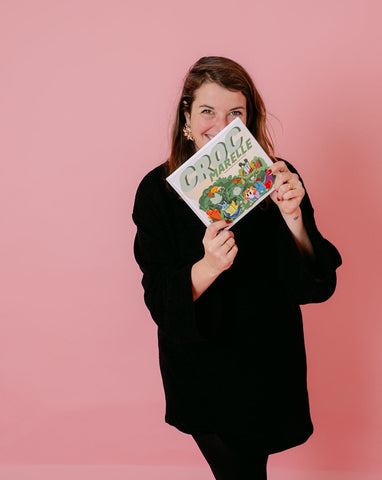 Photo de Manon Brzostek, qui tient entre ses mains son livre intitulé Croc Marelle