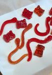 Photos de bons de couleurs rouges en forme d'ourson et de serpent posé sur une assiette blanche