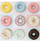 Plusieurs carés aux couleurs pastelles avec à l'intérieur des donuts de posés. Ils sont recouvert de glaçage coloré avec des paillette en sucre.