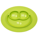 Photo d'un set de table avec assiette intégrée. Le set est de couleur vert. Son assiette est compartimentée en 3,sur la photo sont indiqués les contenant de chaque compartiment. Le set de table est de forme ovale, il ressemble a unvisage