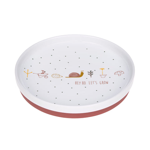 Assiette  pour enfant en porcelaine avec un pied de couleur bordeaux, l'assiette est blanc avec des illustrations sur le theme de la nature : hérisson, escargot, fleurs, brouette