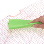 Photo d'un main avec une lavette verte qui nettoie un morceau de tissu