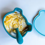 Photo d'un bol pour enfant de couleur bleu en forme de tête d'animal. il contient du fromage blanc avec de la confiture