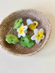Panier en osier contenant des jouets de dentition pour enfant en forme de fleur de thiarée et de trèfles à 4 feuilles