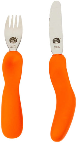  Une fourchette et un couteau aux manches ergonomiques de couleur orange, posé les un a coté des autres. Les couverts sont en inox avec la marque gravé sur le dessus, il s’agit de la marque Nana’s Manners représenté par une tête de mamie