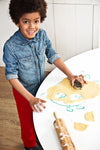 Photo d'un petit garçon qui sourrit et qui est entrain de faire des sablés avec un emporte pièce en inox en forme de lémurien