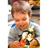 Enfant souriant tenant dans ses mains une gourde avec un pingouin d'illustré dessus