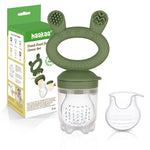 Grignoteuse pour enfant de couleur vert olive avec la marque Haakaa de gravée dessus. Son embout est transparent avec une tétine à trou. Son manche a 2 oreilles avec des textures différentes pour soulager les dents des enfants. La grignoteuse est posée a coté de son emballage en carton