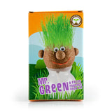 Emballage d’un kit de jardinage pour enfant. C’est une tête à pousser avec du gazon. Le ku s'appelle Mr Green, et il y a une photo sur l’emballage. Il s’agit d’une tête ronde avec des yeux, un nez et un sourire et de l’herbe qui pousse de la tête.