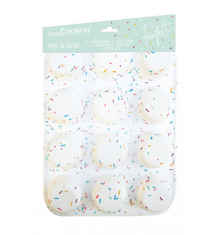 Photo d'un moule en siliocone pour muffin et cupcake. Il est posé sur un fond blanc, il est de couleur blanc avec des confettis multi couleur. Il est composé de 12 alvéoles, sur le dessus du moule est accroché son emballage en carton de la marque ScrapCooking