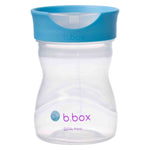 Tasse pour enfant transparente avec un couvercle transparent et un contour bleu. Elle est positionnée sur un fond blanc, la couvercle est plat et forme une coupelle