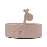 Peekaboo Bol en silicone de couleur rose clair avec des rebords arrondies et une girafe en relief sur le rebord. La photo est prise sur un fond blanc
