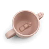 Peekaboo tasse 2 en silicone de couleur rose avec 2 ansses de chaque coté, avec un crocodile à l'intérieur La tasse est sur un fond blanc