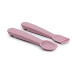 CW2 photo de 2 couverts pour enfants en silicone de couleur rose, il y a une cuillère et une fourchette, elles ont un manche ergonomique evc une petit encoche sur le bout du manche