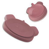 Dos d’une assiette et d’un bol en silicone de couleur roses. Ils sont équipés, chacun, d’une ventouse.