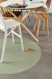 Photo d'une table à manger en bois avec des chaises en bois et une chaise haute blanche. Il y a un gros plan sur un tapis de sol posé en dessous de la chaise blanche, il est rond et un morceau de tarte au fraise est tombé dessus