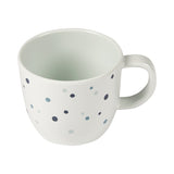 PT Photo d'une tasse blanche avec une anse sur le coté et des petits points bleus