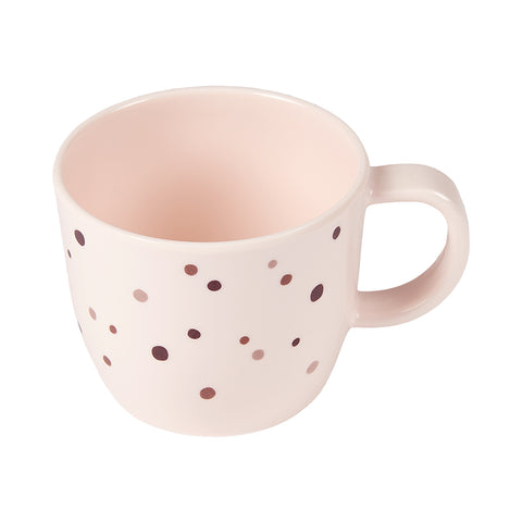 Photo d'une tasse rose avec une anse sur le coté et des petits points roses