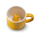 Tasse ne porcelaine pour enfant de couleur extérieur jaune avec une ansse de la même couleur. A l'intérieur la tasse est blanche avec un chat chinois qui fait signe de bonjour de couleur jaune