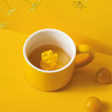 Tasse ne porcelaine pour enfant de couleur extérieur jaune avec une ansse de la même couleur. A l'intérieur la tasse est blanche avec un chat chinois qui fait signe de bonjour de couleur jaune