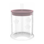 Gobelet pour enfant avec une base ronde transparente avec des motifs texture en forme de fleurs. La tasse à un couvercle qui la referme en silicone de couleur rose, avec une paille transparente à l'intérieur