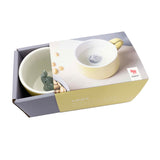 Tasse en porcelaine de couleur jaune avec a l'intérieur un elephant gris en porcelaine. L'intérieur de la tasse est blanche. La tasse est posée  sur un fond blanc et elle est dans son emballage carton de la marque Donkey