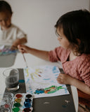 Photo de 2 enfants qui font de la peinture sur des feuilles blaches